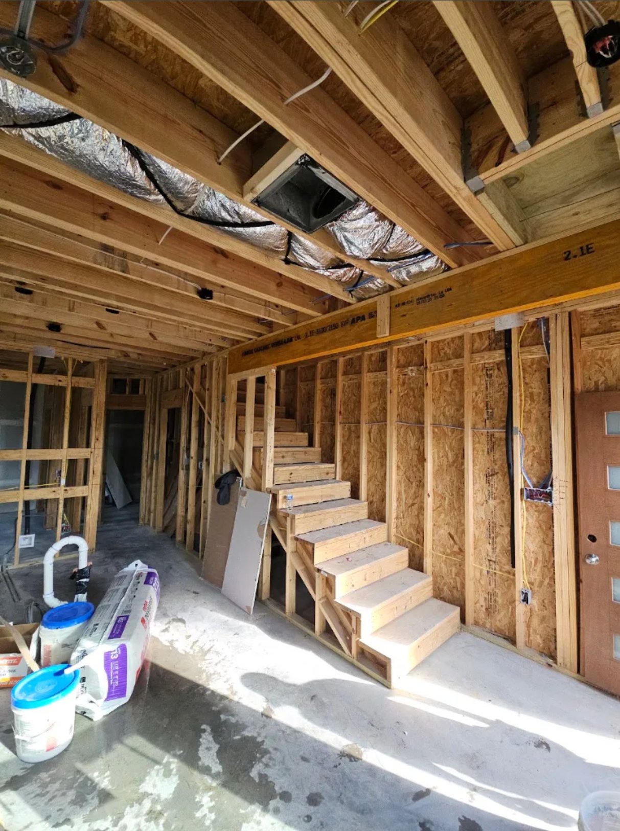 Interior construction of home framing with wooden studs, stairs, and insulation materials